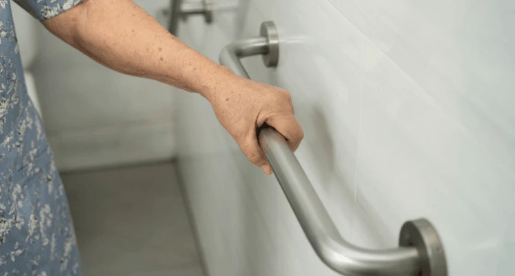 elderly woman holding a handrail